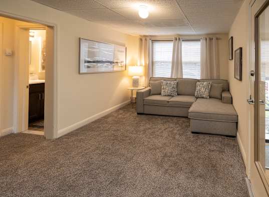 a living room with a couch and a door to a bathroom