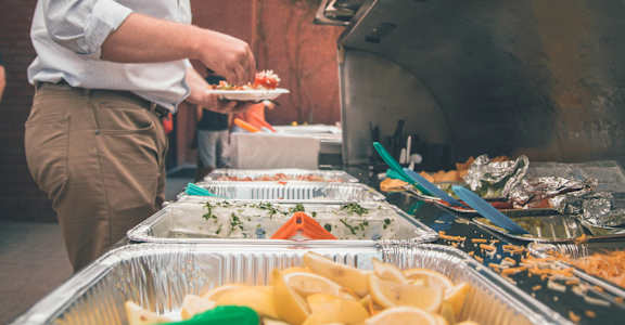 a man preparing food on a grill at a party