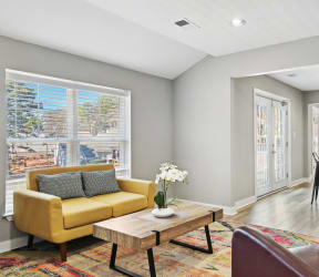 a living room with a yellow couch and a coffee table   and a kitchen  at Emerald Bay, Charlotte, NC