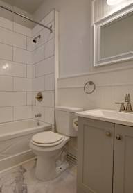 A white bathroom with a toilet, sink, and bathtub.