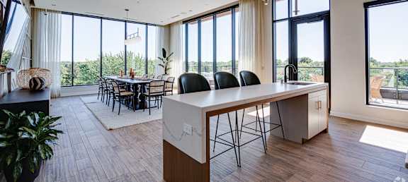 a kitchen with a large island and a dining room with large windows