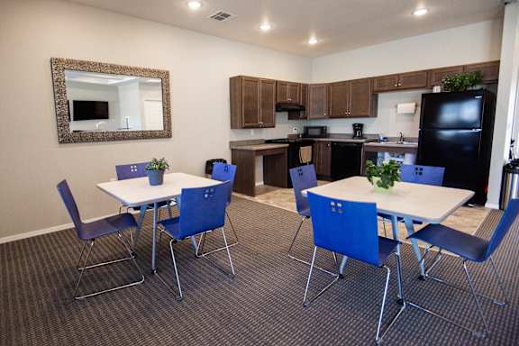 A kitchen with a table and chairs.