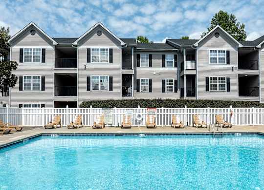 an apartment building with a large swimming pool at Magnolia Pointe Apartments in Duluth, GA
