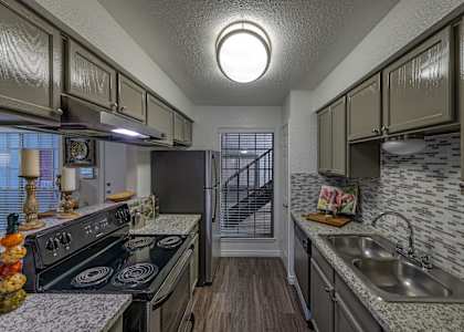 A kitchen with a black stove top oven and a black refrigerator.