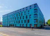 Thumbnail 1 of 8 - a blue building on the corner of a street