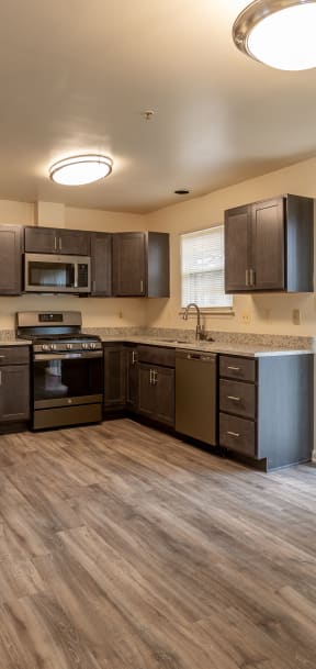 a kitchen with black appliances and wood flooring in an apartment at Carlson Woods Townhomes, Baltimore, MD, 21244