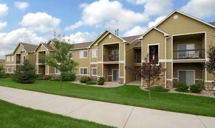A row of houses with a sidewalk in front.