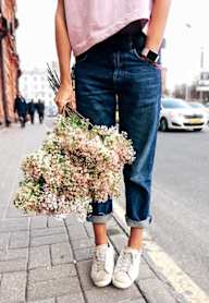 A person is holding a bunch of flowers while standing on a sidewalk.at The Dillon, Los Angeles, CA