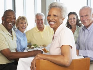 a group of people sitting at a table with food