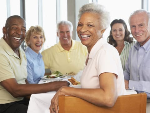 a group of people sitting at a table with food