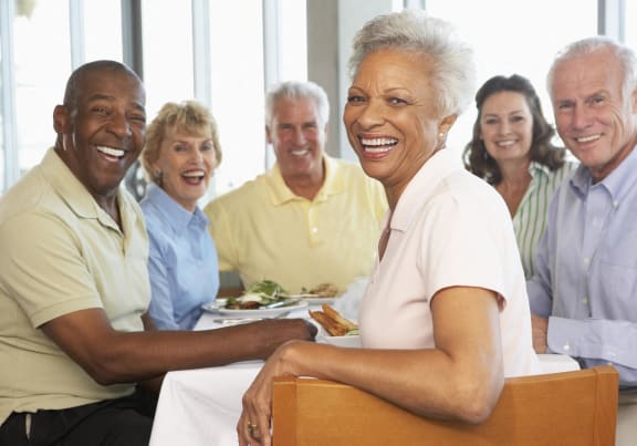 a group of people sitting at a table with food