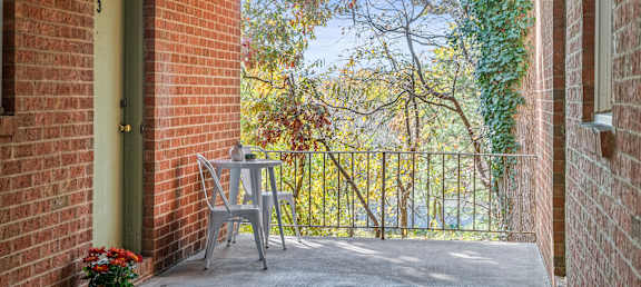 A patio with a table and chairs is surrounded by a brick wall.