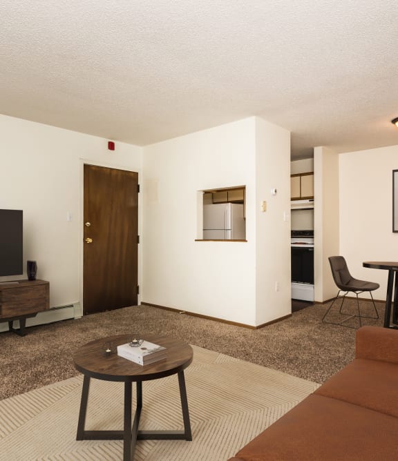 a living room with a couch and a table and a kitchen