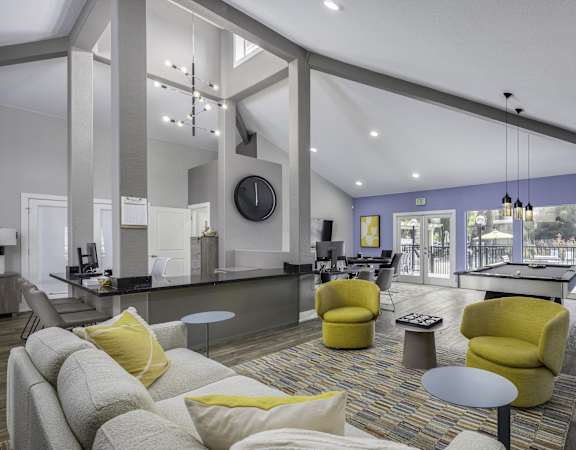 a living room with couches and chairs and a kitchen