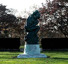 a statue of a man on a pedestal in a park
