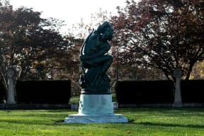 a statue of a man on a pedestal in a park