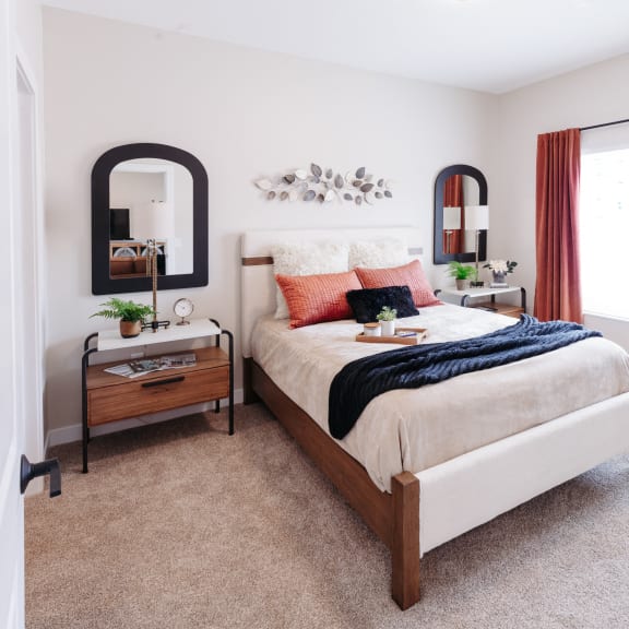 a bedroom with a bed and a mirror on the wall