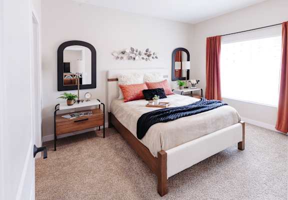 a bedroom with a bed and a mirror on the wall