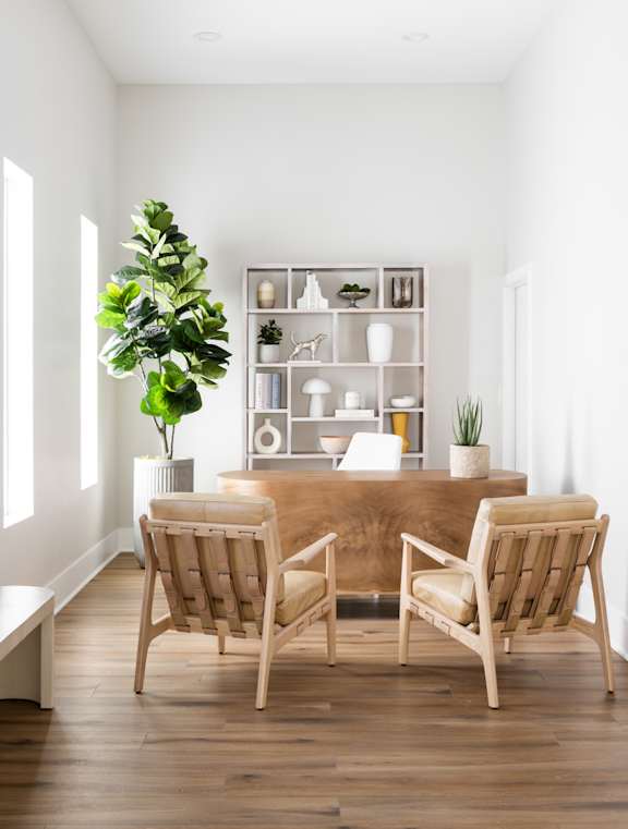 Two chairs are placed in front of a wooden table.