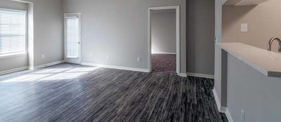 A room with a ceiling fan and a window with blinds.
