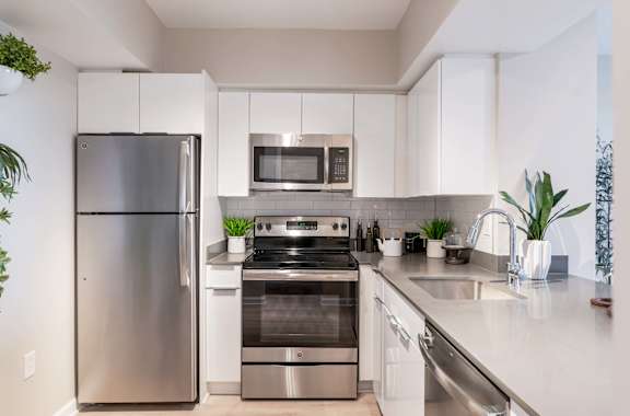 A modern kitchen with stainless steel appliances and white cabinets.