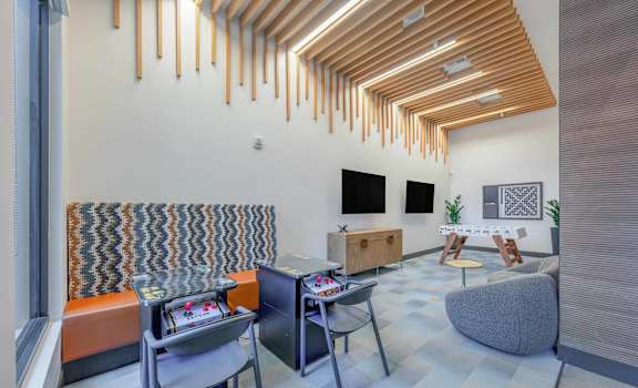 A room with a wooden ceiling and a grey couch.