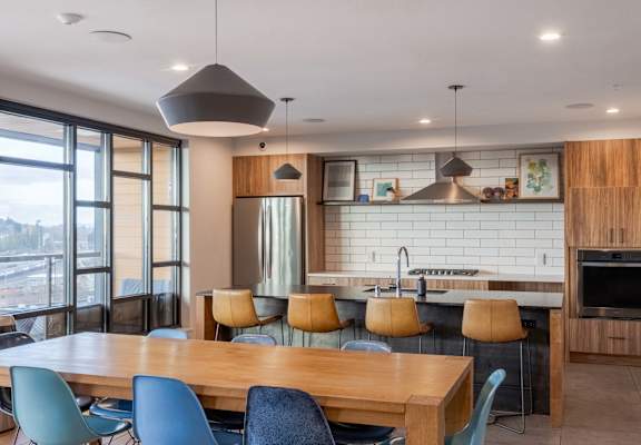 A modern kitchen with a large island and a dining table with chairs.at Axle, Seattle Washington