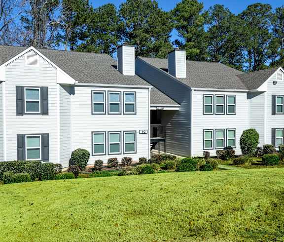 A large house with a grey roof and white walls.