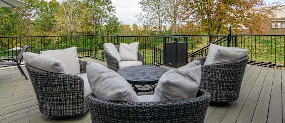 A patio with a table, chairs and a speaker.
