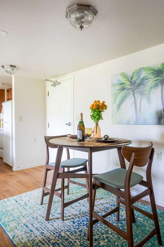 a rendering of a dining room with tables and chairs and a kitchen