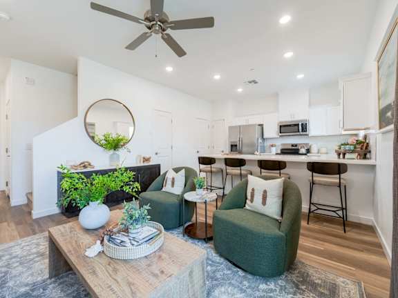 A living room with a grey couch, a coffee table, and a plant.