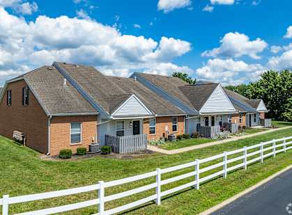 A white picket fence separates a row of houses.