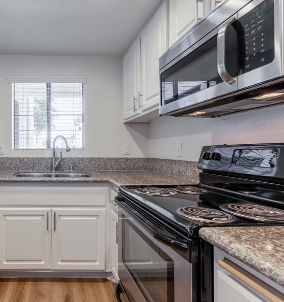a kitchen with granite counter tops and white cabinets