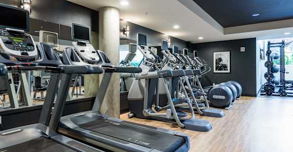 A gym with treadmills and other exercise equipment.