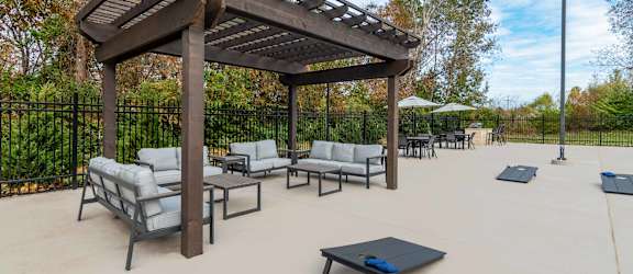 a patio with couches and tables and a wooden pavilion