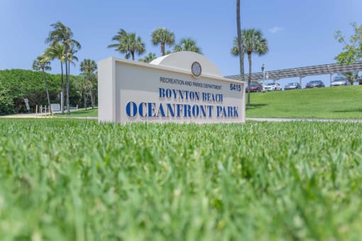 a sign with the words bottomon beach oceanfront park in front of a grassy area