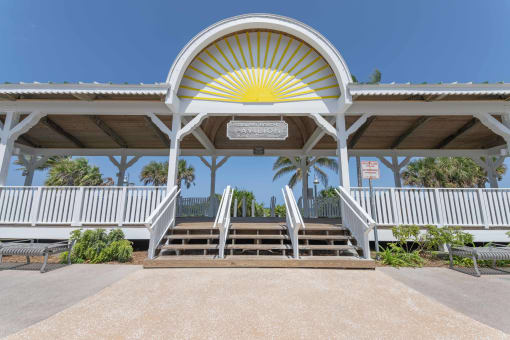 a covered area with benches and a roof with a yellow sunburst