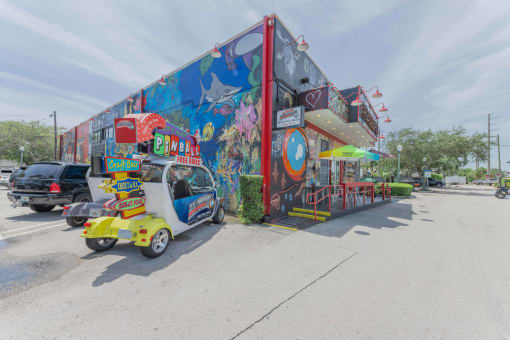a food truck is parked in front of a building with a mural on the side of it