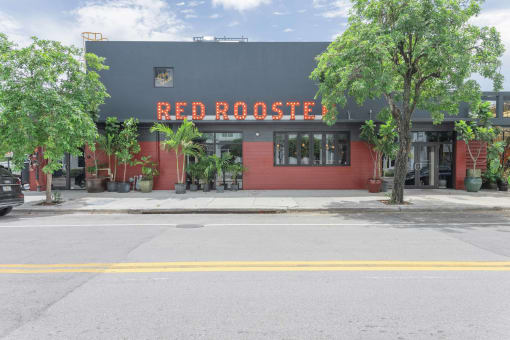 a red rooster restaurant sits on the corner of a street