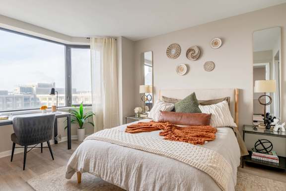 A bedroom with a large bed and a view of the city.