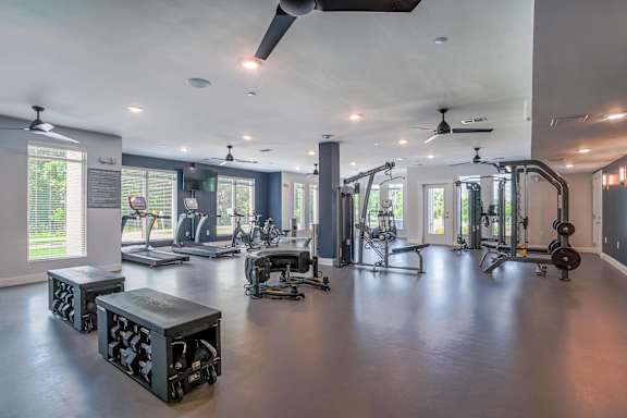 a gym with weights and other exercise equipment and windows