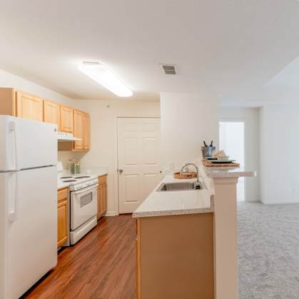 A kitchen with white appliances and wooden cabinets.at Woodwind Villa Apartments, Woodbridge, VA 22191
