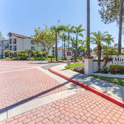 the entrance to mira la quinta apartments with palm trees