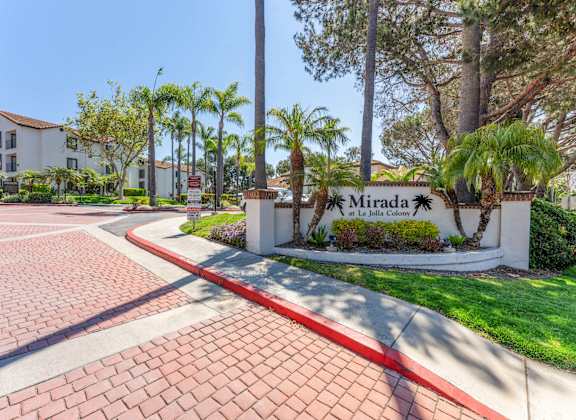 the entrance to mira la quinta apartments with palm trees
