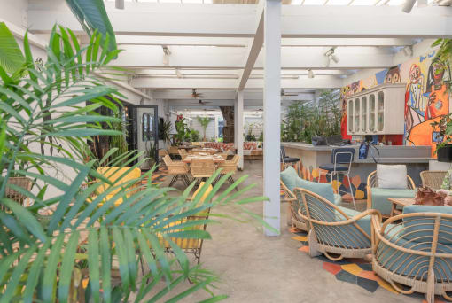 a look at the inside of a restaurant with rattan furniture and a colorful mural on the