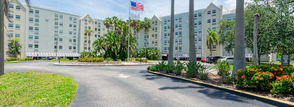 A street view of a hotel with a flag on the building.