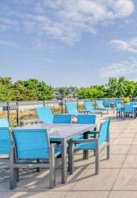 the terrace of the building with tables and chairs and a view of the city