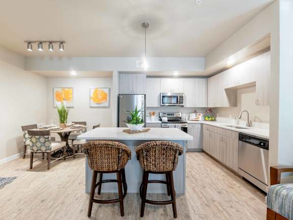A kitchen with a table and chairs in the middle of the room.