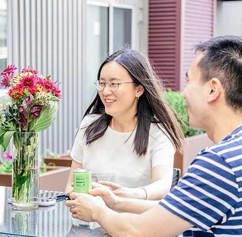 A man and a woman are sitting at a table with a vase of flowers. at Walnut on Highland, Pittsburgh, PA