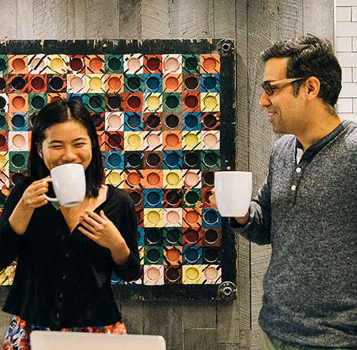 Two people having coffee in front of a wooden wall. at Bakery Living, Pennsylvania, 15206